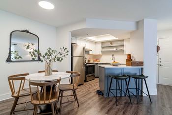 A kitchen with a table and chairs in front of it.